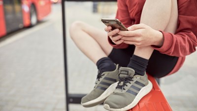 Child uses phone outdoors