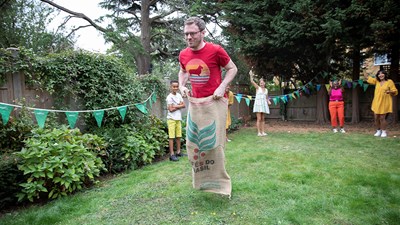 A fundraiser smiling while taking part in a sack race.