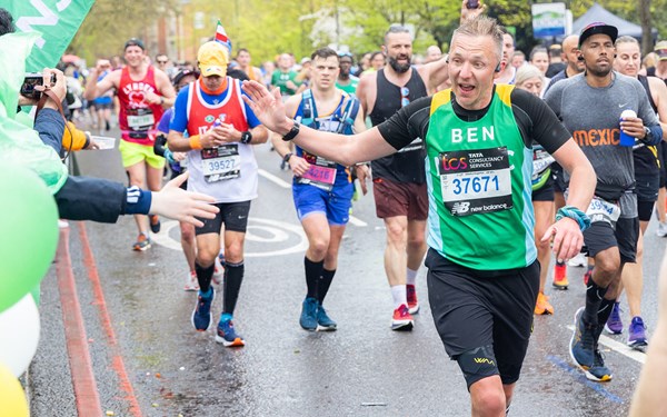 A team NSPCC runner high fiving a spectator