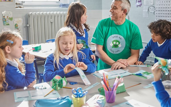 An NSPCC practitioner playing with young children at a school.